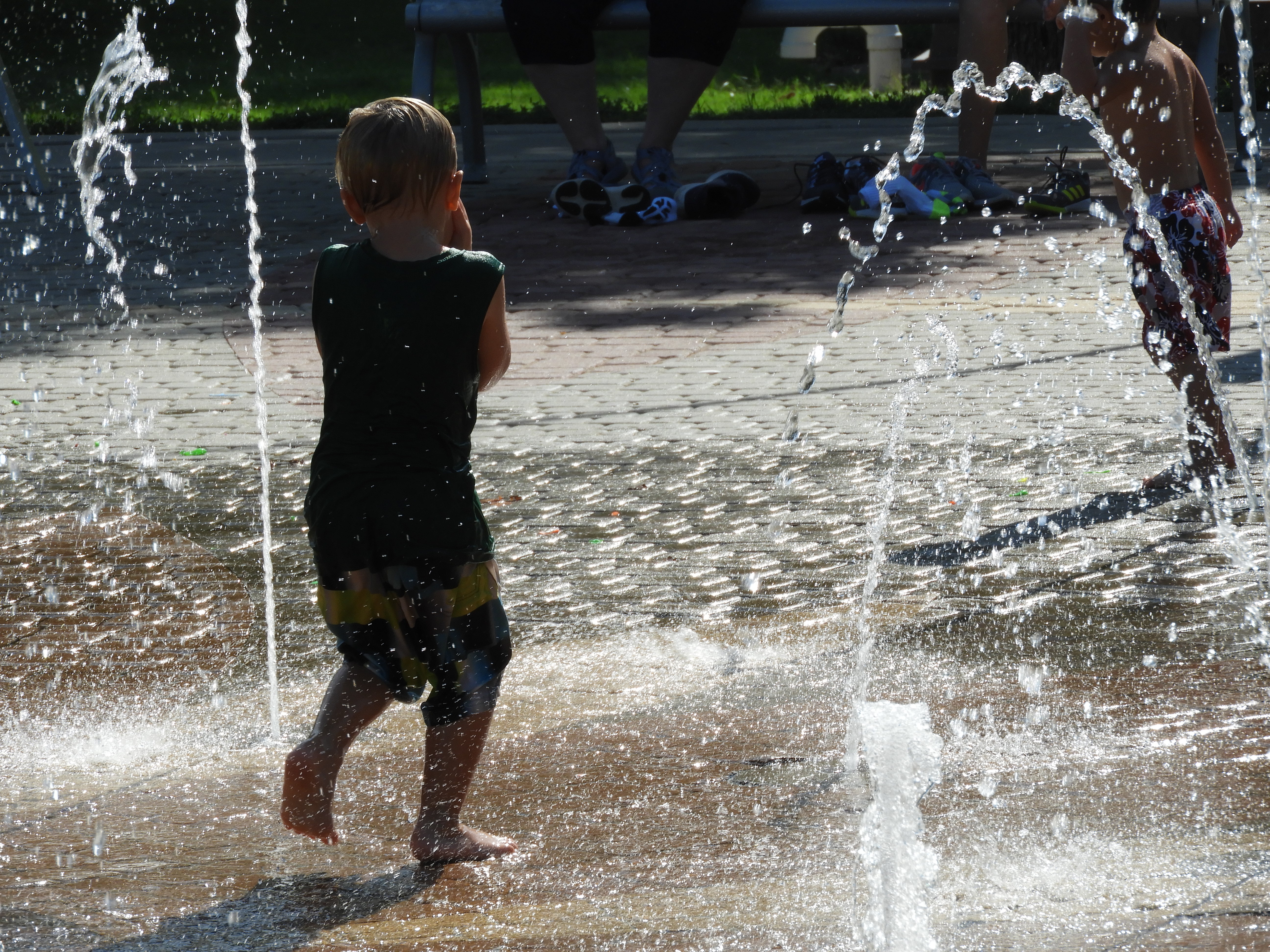 Kids playing in splashing water on a hot summer day in Wichita Kansas